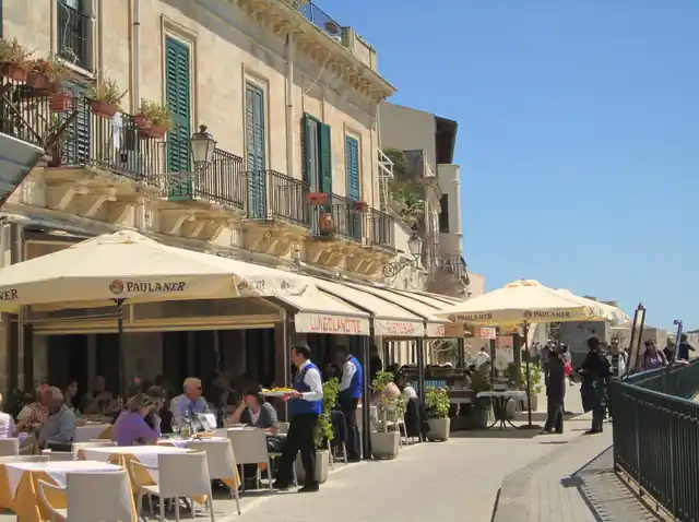 The seafront of Ortigia, Syracuse, with café terraces along the water